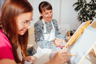 Close-up of young women in casual clothes at a painting...