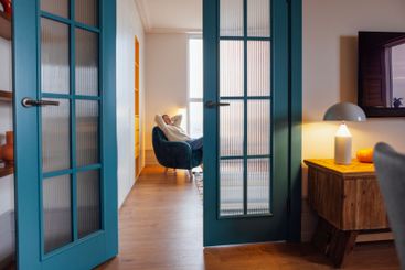 An elderly woman in casual clothes throws her arms up...