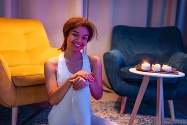 Young African in white fitness outfit is sitting on...