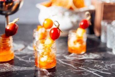A close-up of small jars filled with shrimp and colorful...