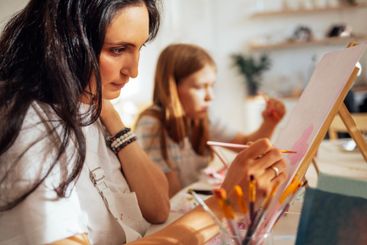 A young focused woman in a white T-shirt and apron...