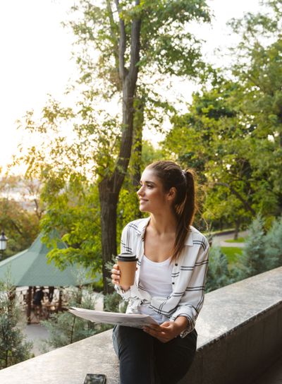 Lovely young student girl sitting outdoors