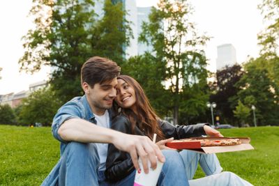 Positive pleased young friends loving couple sitting in...