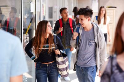 Group Of Smiling Male And Female College Students Walking...