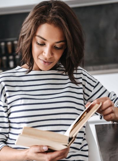Attractive young african woman reading a book