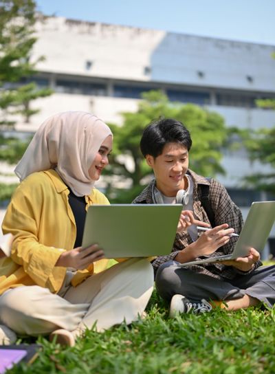 Happy Asian Muslim female college student sharing her...