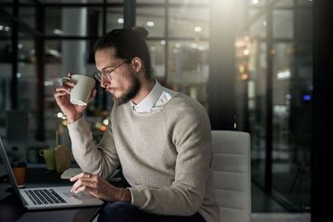 Coffee keeps him going. Cropped shot of a young designer...