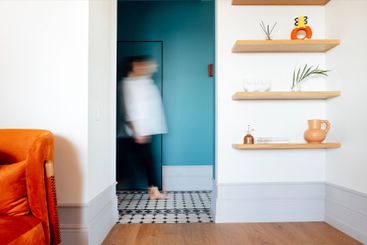A cozy modern living room with white walls, an armchair...