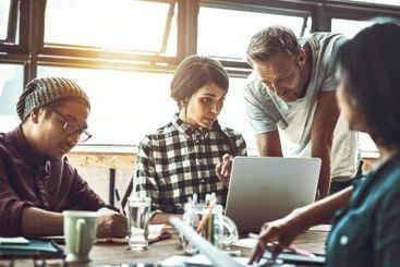 People, creative and laptop in office with manager or...