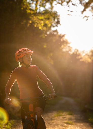 Pretty, young woman biking on a mountain bike enjoying...