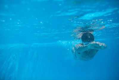 Male swimmer swimming in an outdoor pool - keeping fit