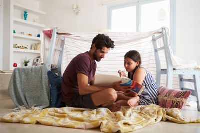Father And Daughter Playing Indoors In Home Made Den