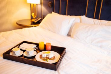 A close-up of a delicious breakfast on a wooden tray is...