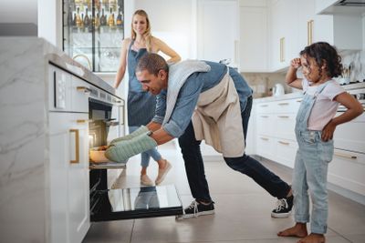 Kitchen, family and father cooking in oven to prepare...